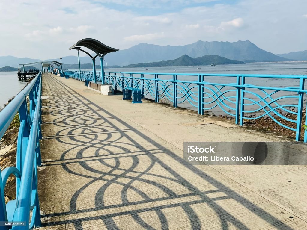 Pier A long pier under a sunny day with beautiful shadow on the ground presents a happy, relaxing and holiday mood Asia Stock Photo