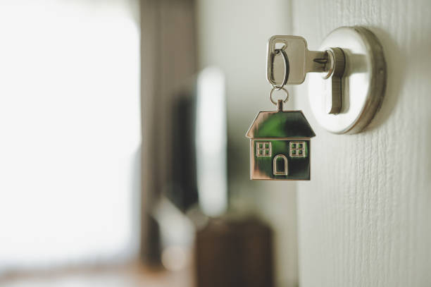 apri la porta e la maniglia della porta con una chiave e una casa a forma di portachiavi. investimento immobiliare e mutuo casa concetto di immobili finanziari - portachiavi foto e immagini stock