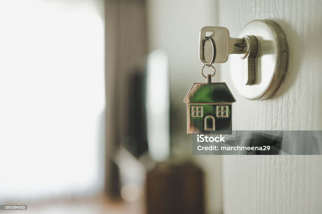 Open the door and door handle with a key and a keychain shaped house. Property investment and house mortgage financial real estate concept Home Ownership Stock Photo