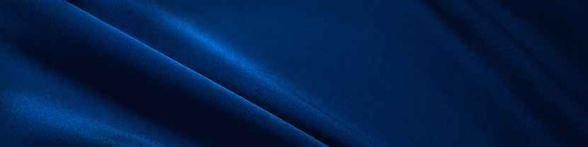 Blue silk satin. Folds in the fabric. Elegant background with copy space for design. Web banner. Website header.