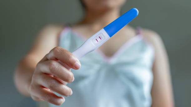 istock Positive pregnancy test on a woman's hand in pajamas. 1351211073