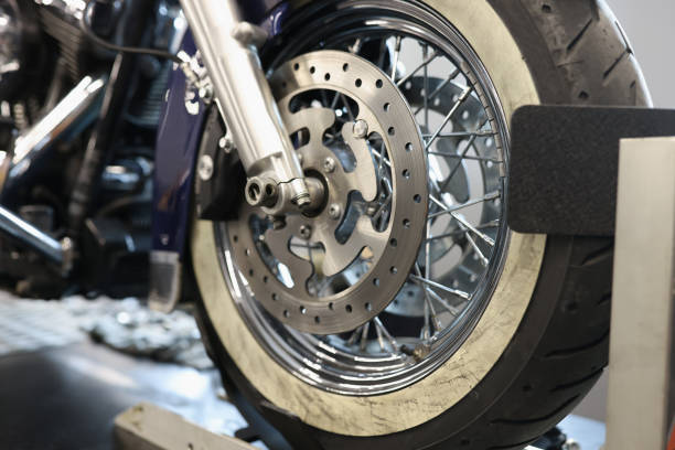 istock Front motorcycle wheel with shiny brake disc closeup 1351212126