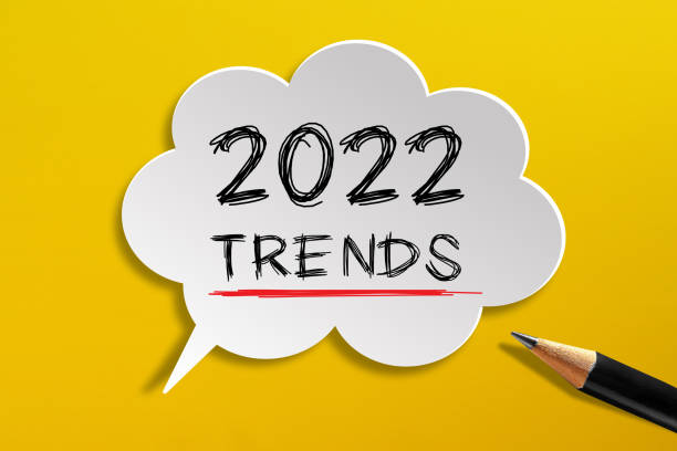 2022 trends auf sprechblase mit bleistift auf gelbem hintergrund geschrieben - feiertag grafiken stock-fotos und bilder