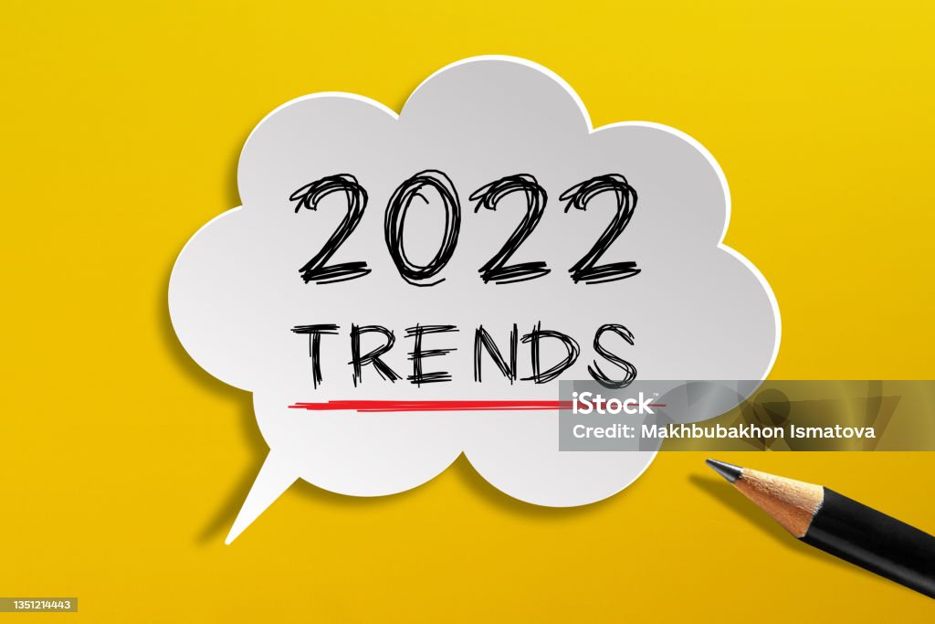 2022 Trends written on speech bubble with pencil on yellow background Graph Stock Photo