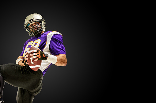 American football player in action with ball.
