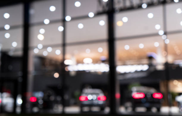 Blurred background with car dealership exterior. Abstract blurred photo of modern building motor showroom. Blur car show room office bokeh lights. Automobile retail shop stock photo
