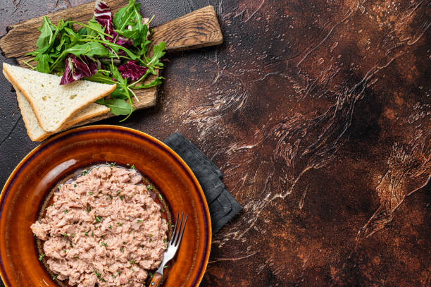 istock Tuna canned fish with bread and salad. Dark background. top view. Copy space 1351220258