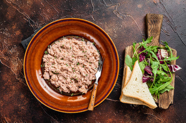 istock Tuna canned fish with bread and salad. Dark background. top view 1351220278