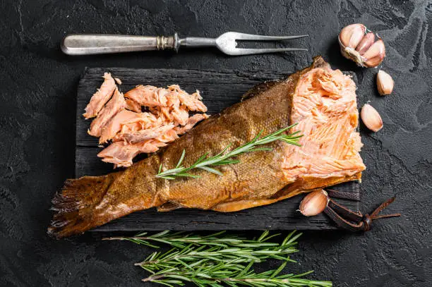 Salmon Hot smoked,  trout fish meat. Black background. Top view.