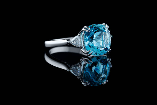istock Beautiful gold ring with aquamarine and diamonds on a black background 1351220491