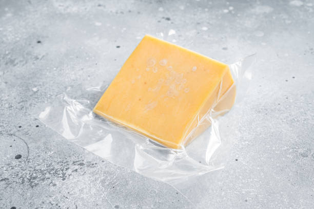 istock Organic Sharp Cheddar Cheese in vacuum packaging. Gray background. Top view 1351220568