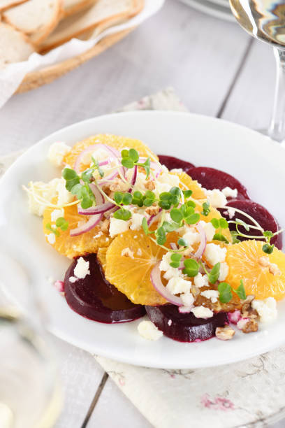 istock Orange salad with baked beetroot, goat cheese, microgreens and nuts. Perfect as a side dish or as a light lunch for a brunch or dinner. 1351222695