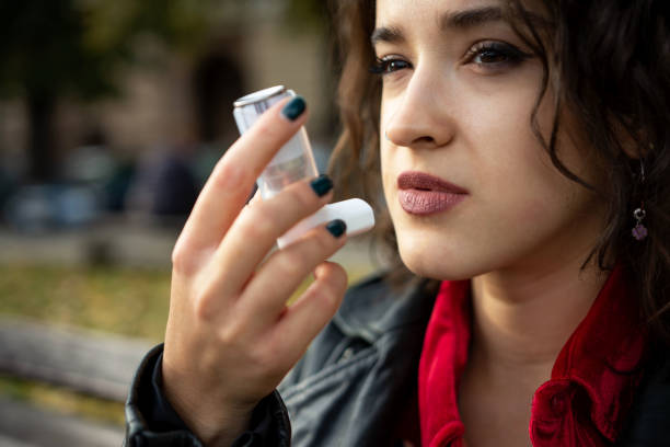 istock Young woman treating asthma with inhaler 1351224975