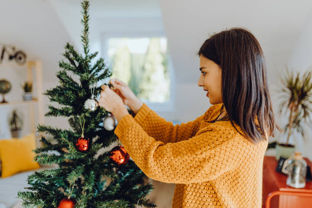 istock young women decorating her home for christmas 1351226307