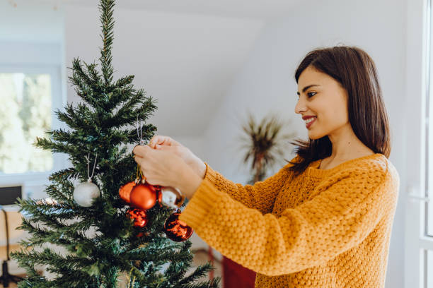 istock young women decorating her home for christmas 1351227229
