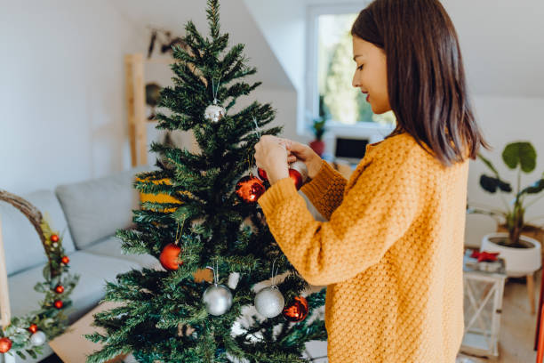 istock young women decorating her home for christmas 1351227234
