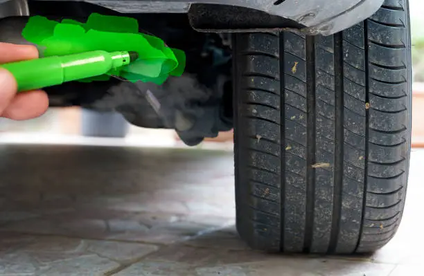 Photo of hand painting a car exhaust pipe green