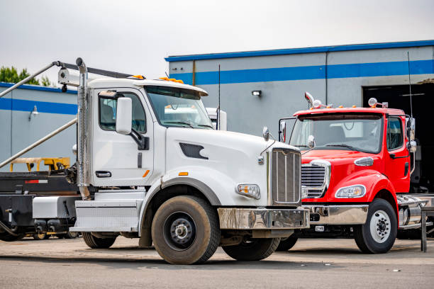 istock Two skid-mounted big rigs day cab semi trucks for transporting waste containers are parked in a warehouse awaiting another order 1351231404