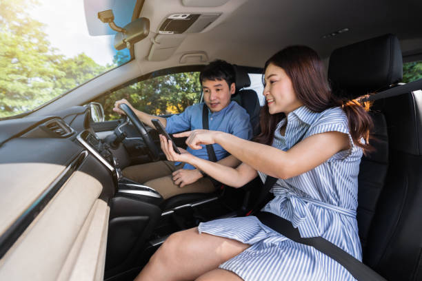 istock couple in a car looking map in smartphone for direction 1351233156