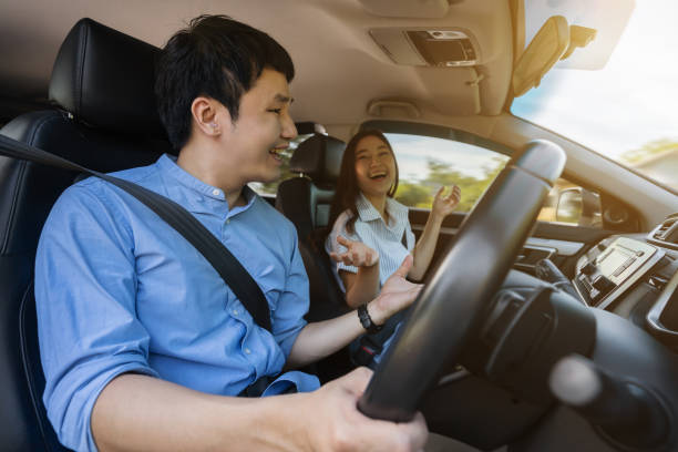 istock happy couple is talking while driving a car 1351233158