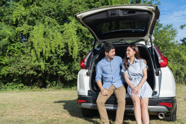 istock happy couple sitting in open car back 1351233188