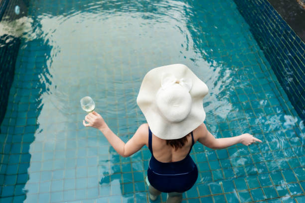 istock woman relax in swimming pool and drinking wine 1351233580