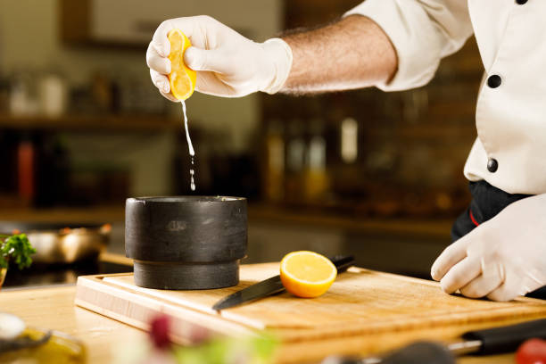 istock Unrecognizable chef squeezing lemon juice into mortar and pestle. 1351234972