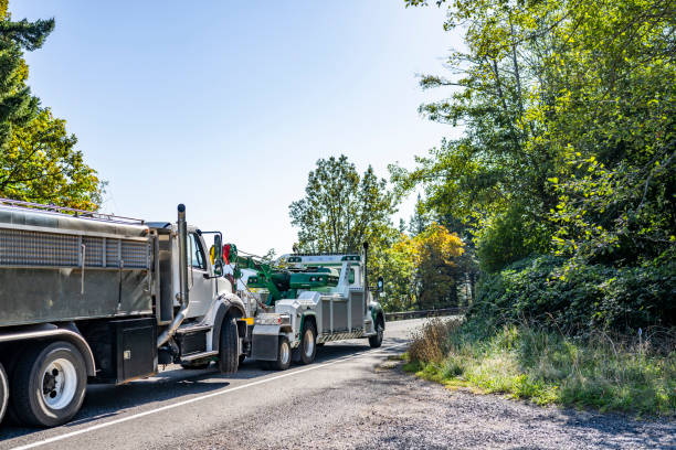 tow truck hauling a garbage truck