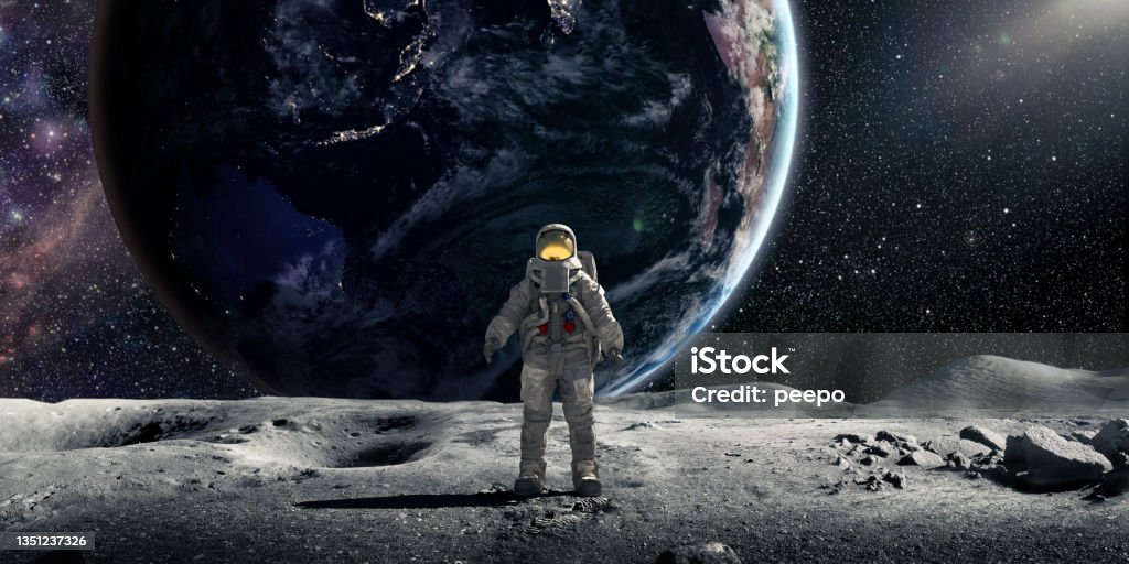 Astronaut Standing On Moon Facing Towards Camera With Earth In Background An astronaut wearing full spacesuit and backpack, standing in the lunar surface of the moon facing the camera. Behind the astronaut is the earth, with night lights visible from some countries and the sun rim lighting on side. Earth Image from NASA: https://earthobservatory.nasa.gov/ContentFeature/NightLights/images/media/BlackMarble_2016_Asia_composite.png Moonwalk Stock Photo