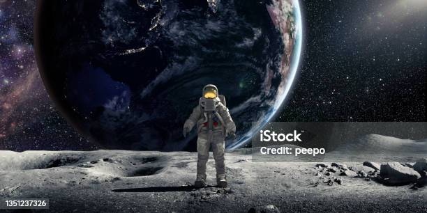 Astronaut Standing On Moon Facing Towards Camera With Earth In Background Stock Photo - Download Image Now