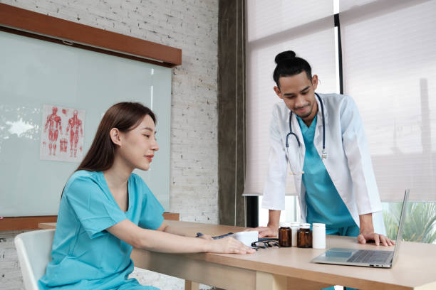 istock Two uniformed young doctors work in medical clinic office. 1351237766