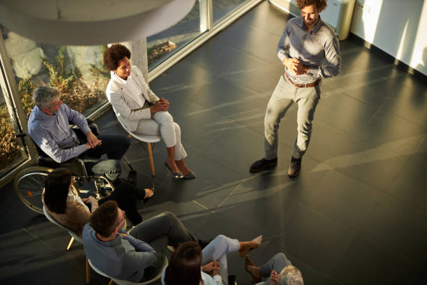 istock Above view of happy coach talking on a group therapy in the office. 1351239257