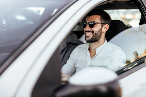 attraktiver eleganter glücklicher mann in gutem auto. - driving new car driver stock-fotos und bilder
