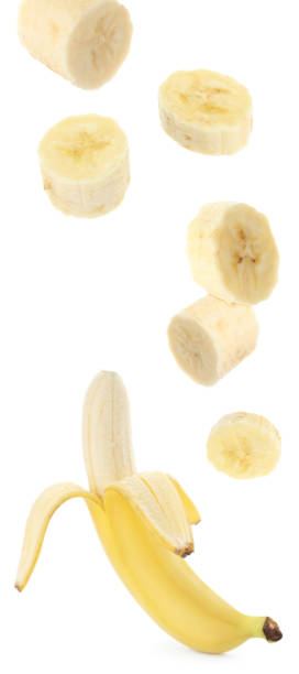 istock Set with delicious ripe banana and pieces falling on white background 1351241494