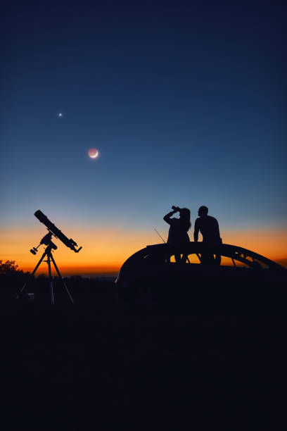 istock Couple stargazing together with a astronomical telescope. 1351249958