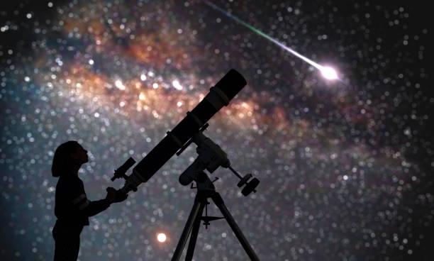 istock Girl with astronomical telescope stargazing under starry sky. 1351250014