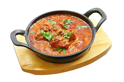 Overhead  shot of Chicken tikka masala baked in little pan. Isolated on white with clipping path