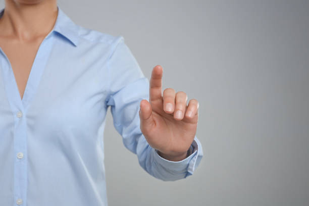 istock Woman touching something against grey background, focus on hand 1351251232