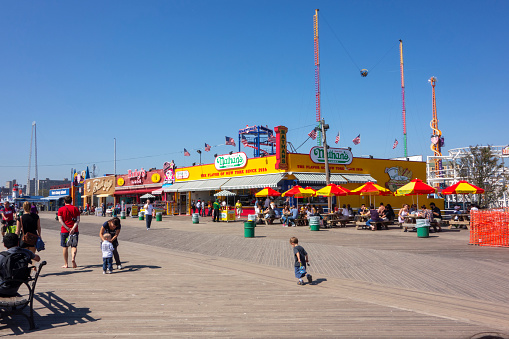 New York City, NY, USA - September 20 2013: People enjoying last days of summer on the boardwalk of Coney Island on a sunny day
