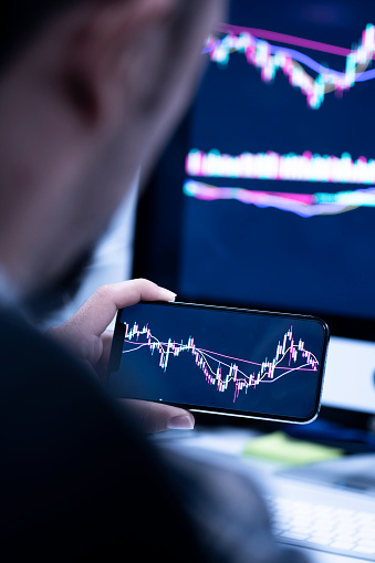 Businessman using laptop for analyzing data stock market, forex trading graph, stock exchange trading online, financial investment concept. All on smartphone screen are design up.