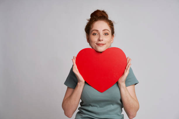 istock Young and beautiful woman with red heart 1351253392
