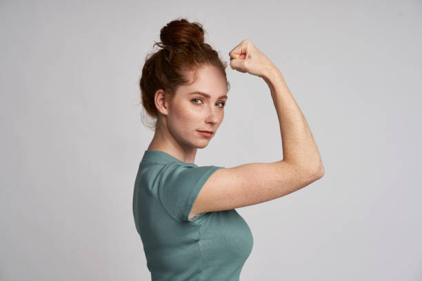 istock Young woman showing sign of girl power 1351253473