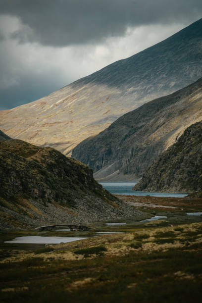 istock Exploring wilderness. Mysterious mountain landscape and lakes. Scandinavian descent 1351256388