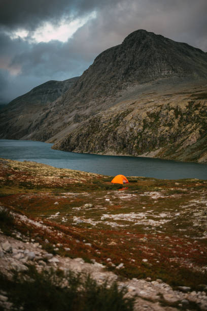 istock Exploring wilderness. Mysterious mountain landscape with lake. Camp with tent 1351256471