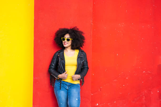 istock Smiling american-african woman standing on a colored background 1351257400