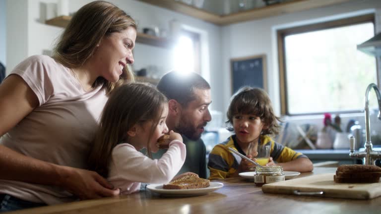 Family eating breakfast in kitchen at home