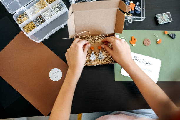 Young unrecognisable woman preparing her earrings for delivery Young unrecognisable woman preparing her earrings for delivery polymer clay stock pictures, royalty-free photos & images