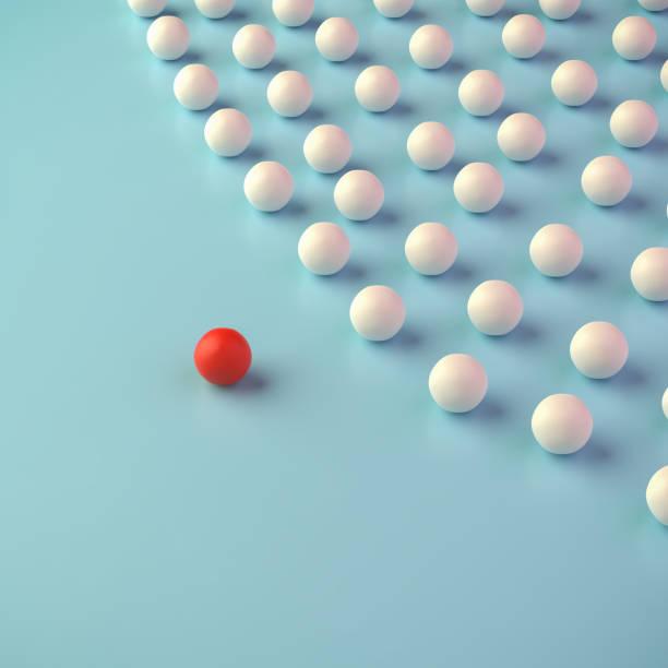 istock Leadership Concept: A group of white spheres with one sphere in red leading the group. 1351263171