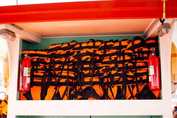 Orange and black lifejackets in a row. Security, rescue and help concept.Orange and black lifejackets in a row. Security, rescue and help concept.