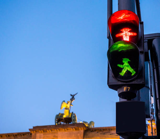 two icons of Berlin. Ampelman and Brandenburger tor. two icons of Berlin; Branderburger tor and the Ampelmann.  Typical and famous pedestrian traffic light of Berlin with walking green man "Ampelmannchen".  Pedestrian light is made by German technology company Siemens (see bottom left of light)." ampelmännchen photos stock pictures, royalty-free photos & images